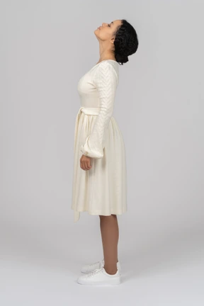 Young woman standing sideways to camera and keeping her head up