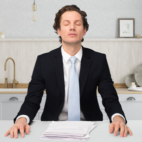 A man sitting at a desk with his eyes closed