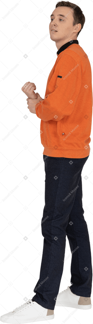 Young man in orange sweatshirt standing