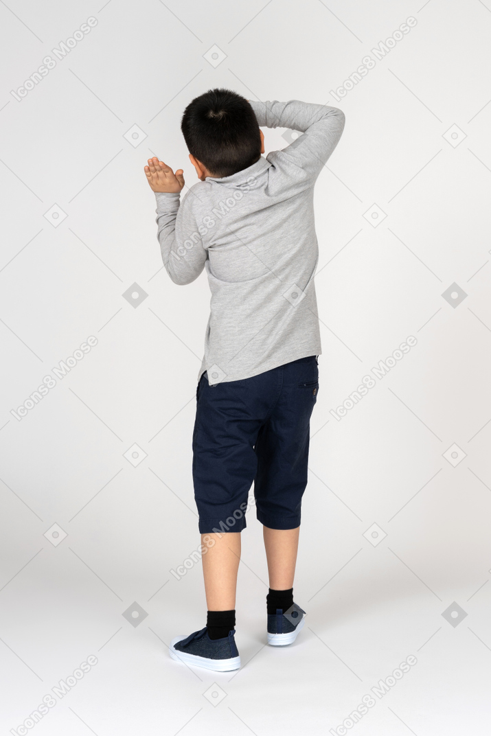 Rear view of a boy covering his head