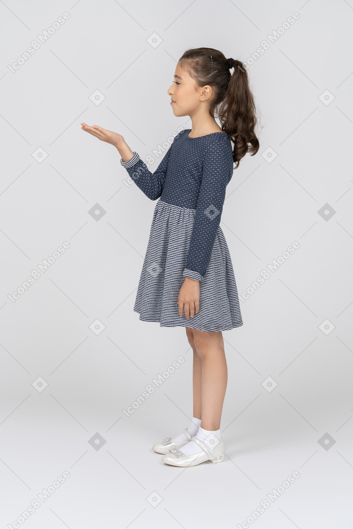 Side view of a girl holding out her palm