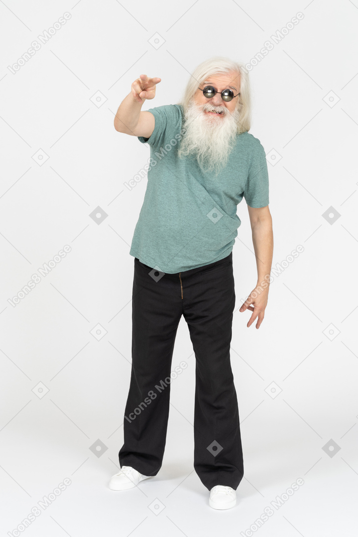Front view of old man in sunglasses pointing two fingers at camera