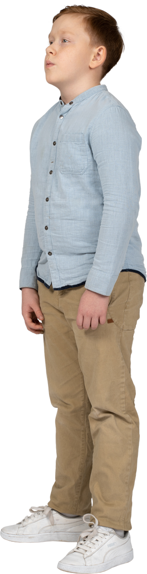 一个穿着休闲服的男孩站着不动的侧视图