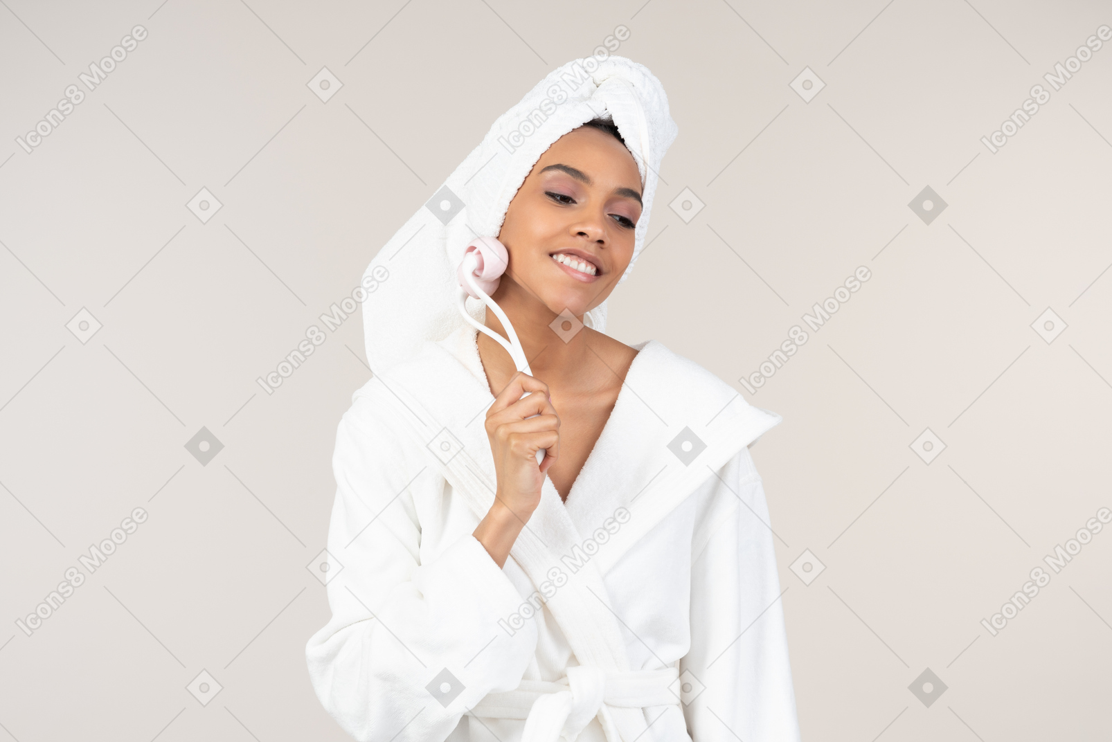 Femme noire en peignoir blanc et une serviette de tête profitant de sa routine de soins de la peau