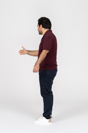 Side view of a man reaching out his hand