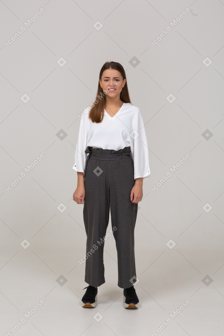 Front view of a confused young lady in office clothing