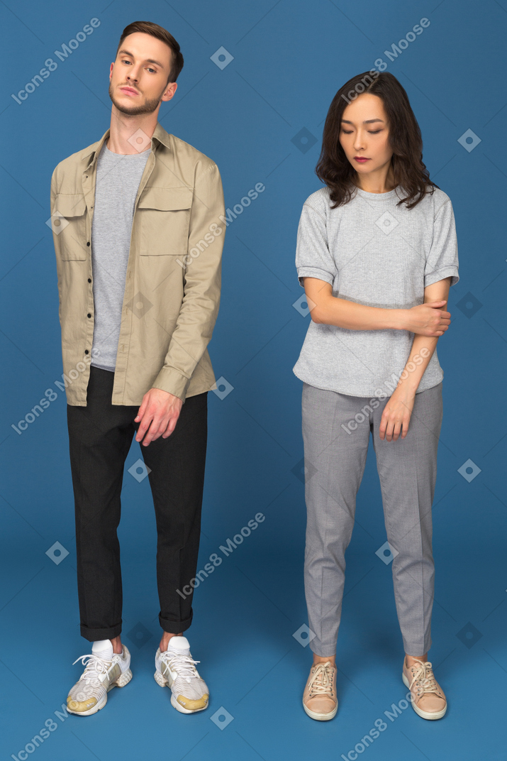 Young couple standing still in front of camera