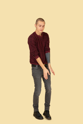 Three-quarter view of a dancing young man dressed in red pullover