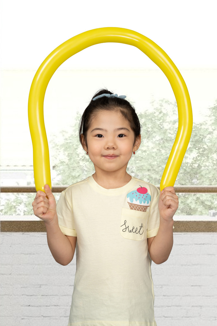 Cute asian girl playing with a yellow balloon
