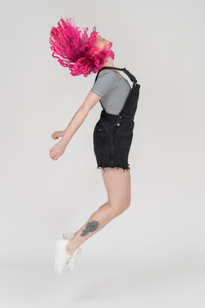 A pink haired girl jumping up