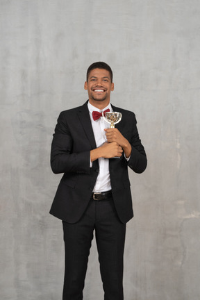 Hombre sonriente en traje sosteniendo un premio