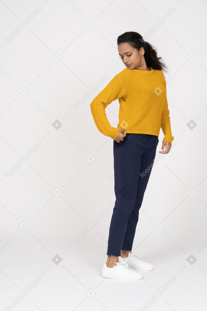 Front view of a girl in casual clothes looking at her shirt