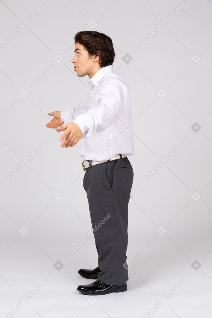Surprised young man spreading arms