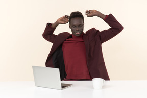 Elegante hombre negro sentado a la mesa en la oficina