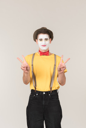 Male clown showing peace signs