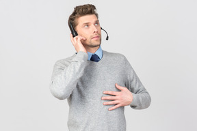 Call center agent touching headset and looking up