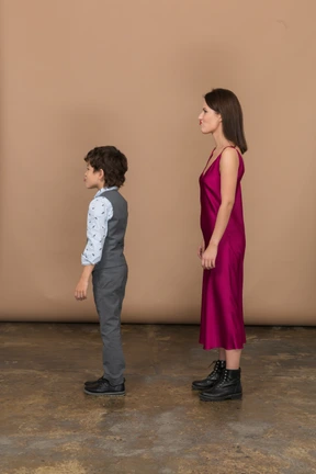 Mujer en vestido rojo y niño de perfil