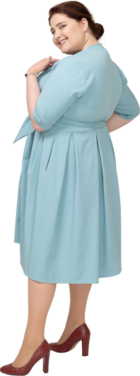 Donna in abito blu in posa di profilo