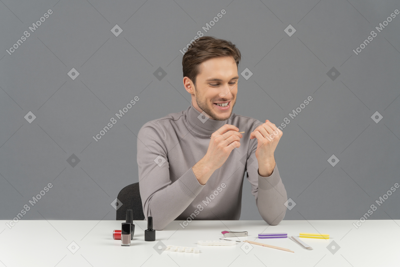 A cheerful young man doing his nails