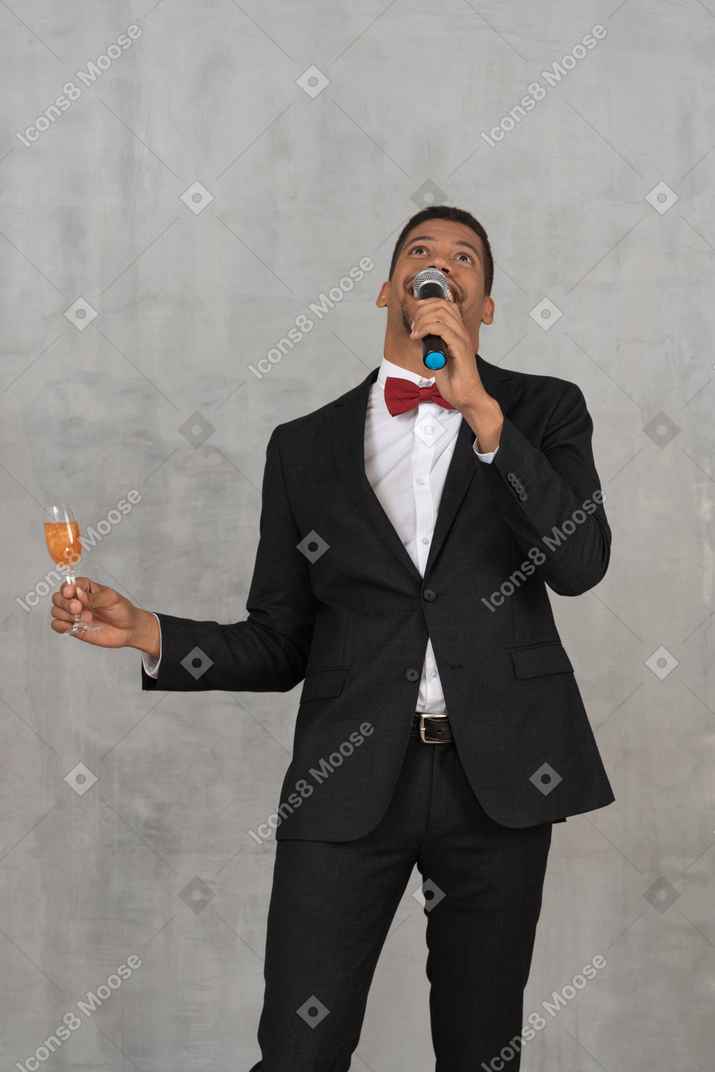 Mann mit mikrofon und flötenglas, das nach oben schaut