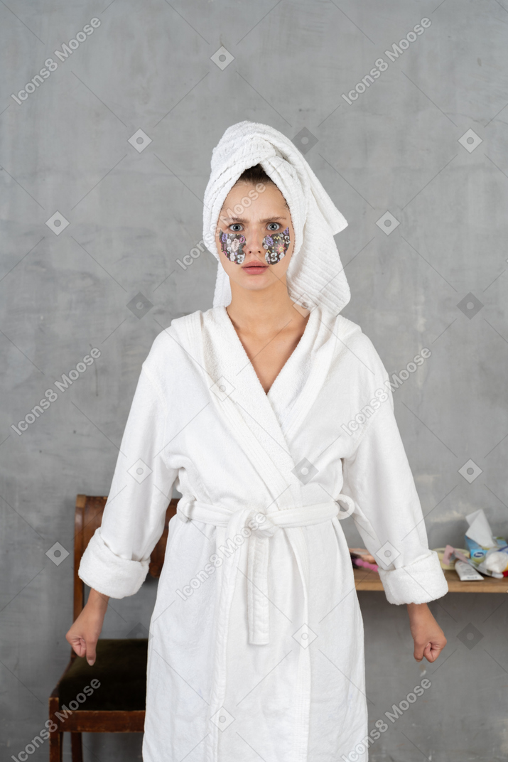 穿着浴袍的女人攥紧拳头看起来很生气