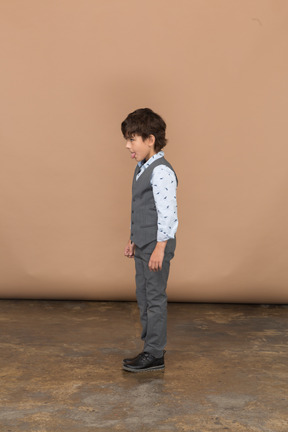 舌を示す灰色のスーツを着た少年の側面図
