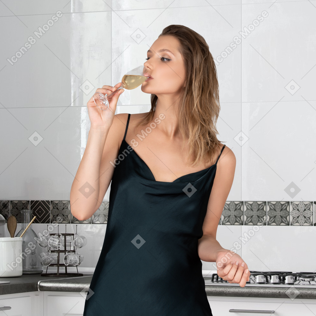 A woman in a black dress drinking from a wine glass