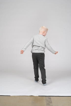 Back view of a boy in casual clothes spinning around