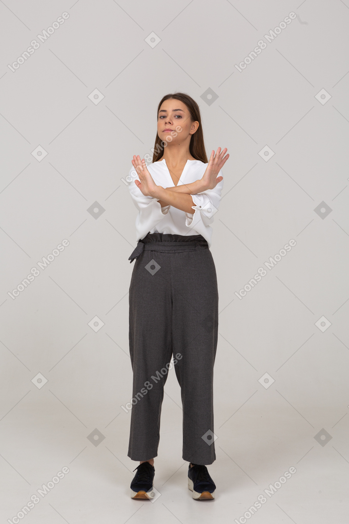 Vista frontal de una señorita en ropa de oficina cruzando los brazos