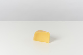 Trozo de queso sobre fondo gris