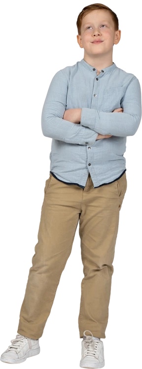 Cute boy standing with crossed arms and looking up