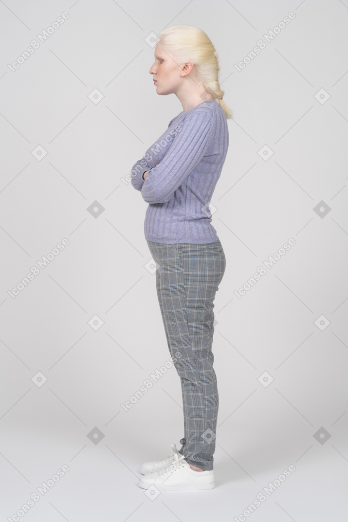 Side view of woman standing with crossed arms