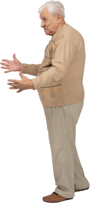 Vista lateral de um velho feliz em roupas casuais em pé com os braços estendidos