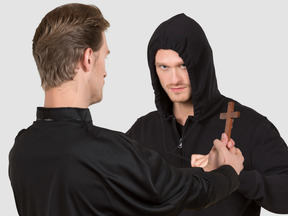 Priest stopping a man with cross