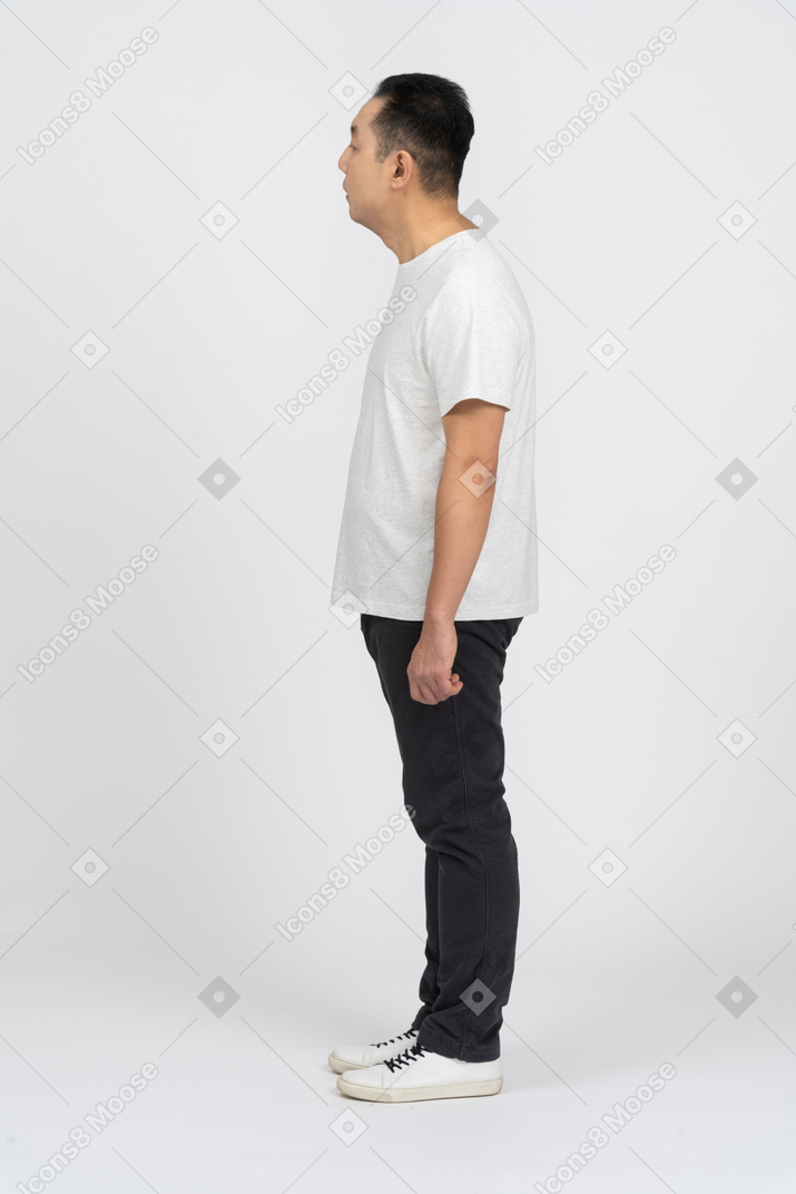 Vista lateral de un hombre con ropa informal mirando algo con interés