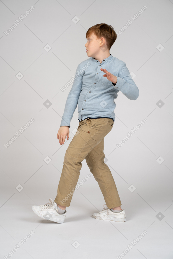 Vista lateral de um menino andando
