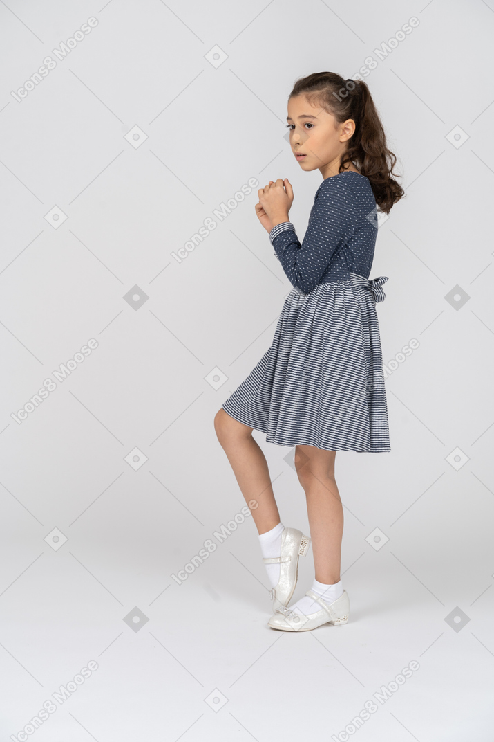 Side view of a girl shrinking and cowering warily