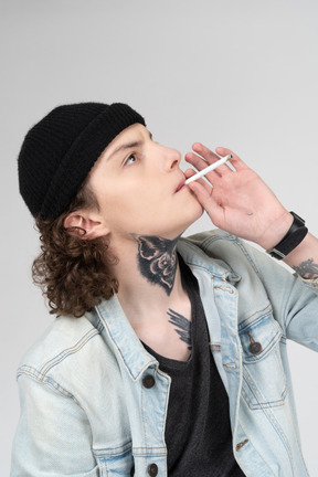 Подросток курит сигарету