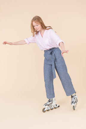 Young woman balancing on rollerblades