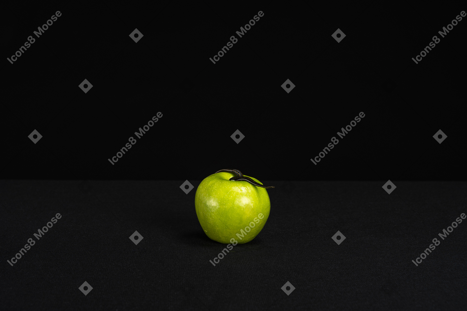 A lonely green apple in black background