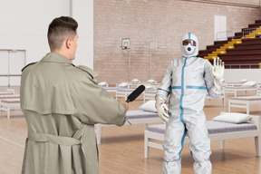 Reporter asking a man in a protective suit for an interview