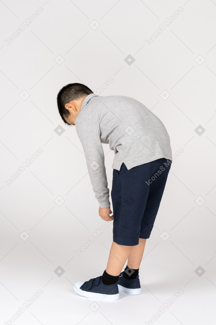 Rear view of a boy leaning forward