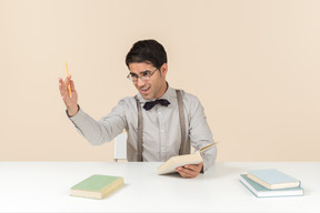 Profesor sentado a la mesa y leyendo libros