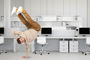 A man doing a handstand in an office
