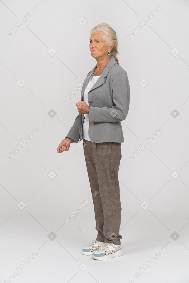 Angry old lady in suit posing in profile