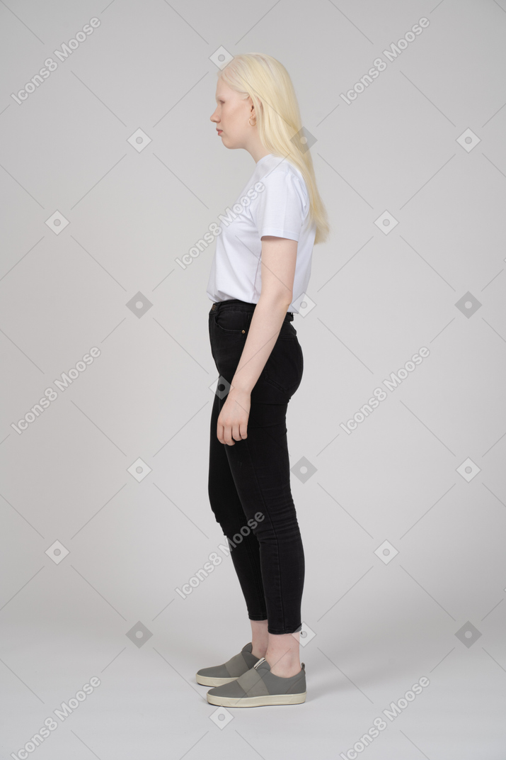 Vista de perfil de una mujer joven con ropa informal mirando hacia otro lado