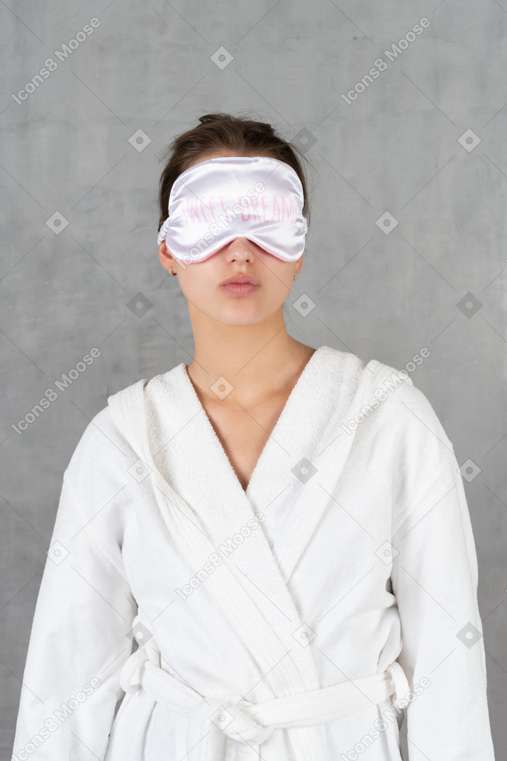 수면 마스크를 쓴 목욕 가운을 입은 여성