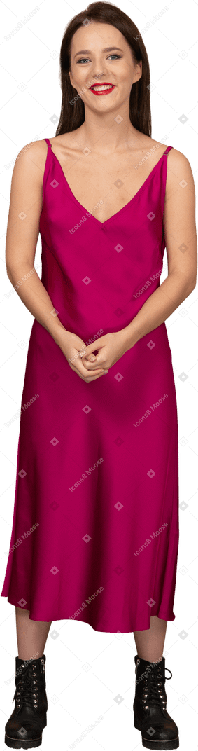カメラを見て美しい赤いドレスを着て幸せな若い女性の正面図