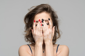 Mujer cubriéndose la cara con ambas palmas