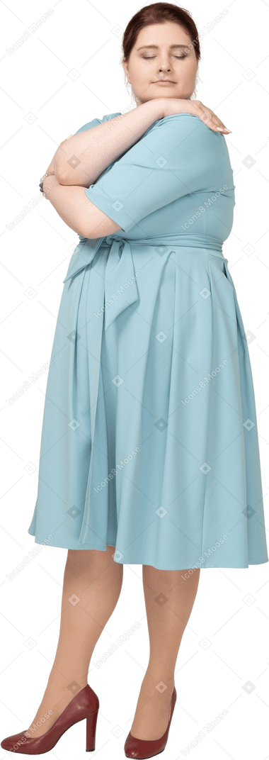 Vista frontal de uma mulher de vestido azul se abraçando